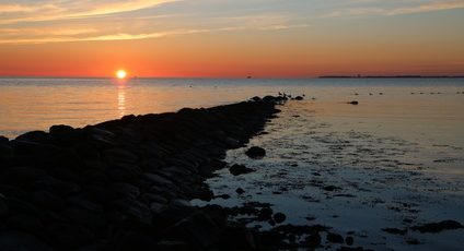 malerischer Sonnenaufgang an einer Steinmole an der Ostsee